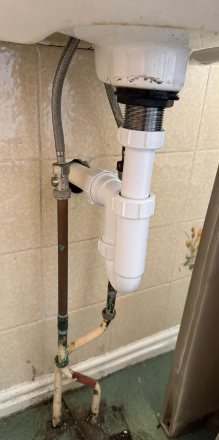 Repaired bathroom basin pipework and tap after a leak in Heaton